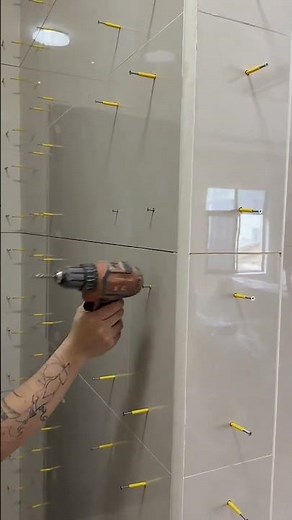 Precision Wall Tile Installation Using Leveling Spacers and Drill for Perfect Alignment