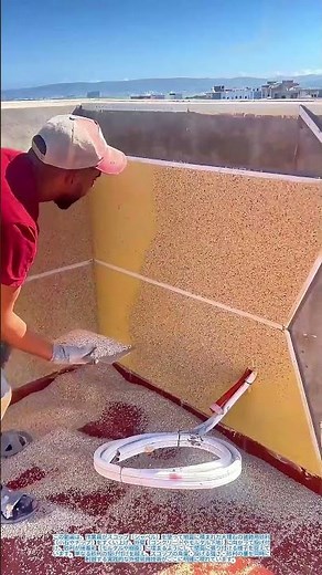 スコップで大理石の装飾砂利をすくい、壁面に撒いて接着させる：外壁装飾のための投げ付け施工法