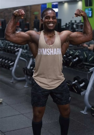 Xandre has a striking, athletic physique that clearly reflects consistent strength training and disciplined fitness habits. His body shows a well-developed muscular structure, particularly visible in his arms, shoulders, and chest. The pose he’s holding—flexing both arms—highlights pronounced biceps and triceps with clear muscle separation. His deltoids appear rounded and full, creating a strong upper-body silhouette. The chest is thick and defined, tapering down into a lean waist that emphasize