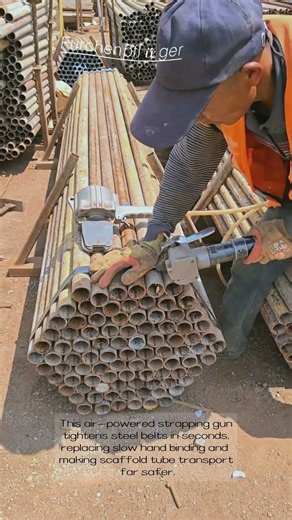 Construction Worker Uses Pneumatic Strapping Tool To Bundle Stacked Scaffold Steel Tubes