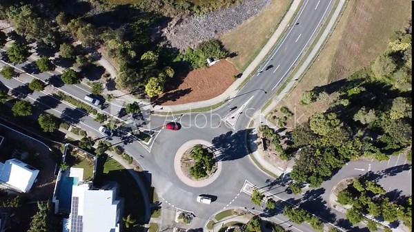 Drone hoovering over a suburban roundabout with light traffic in Australia