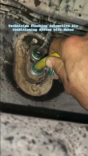 Technician Flushing Automotive Air Conditioning System with Water