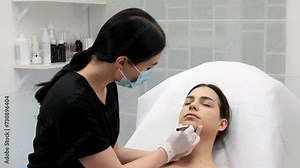 The cosmetologist makes markings on the patient's face, drawing correction lines before the facial contouring procedure or plastic surgery. preparation time for cosmetic treatment.