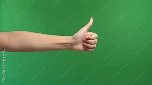 Closeup Of Female Hand Showing Thumbs Up Sign Against Green Screen Background