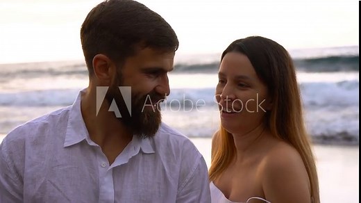 Happy young couple kissing each other on the beach during summer vacation - Travel, holiday and relationship concept