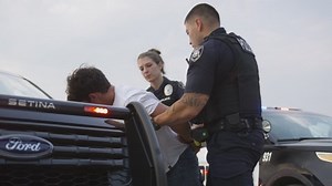 Police Officers Pat Down Man After Arrest
