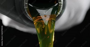 Time lapse of motor oil being poured on yellow black background. Choosing a quality engine oil