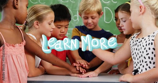 Students leaning around table in classroom, Learn More graphic appearing, hands stacking for unity