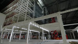 Cargo-passenger lift within industrial complex for transporting goods across levels. Employees utilize freight-passenger elevator in industrial area