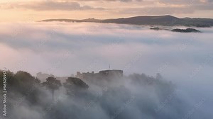 Aerial clip of Castle Drogo in Dartmoor National Park at sunrise on a misty morning, Devon, England, United Kingdom, Europe