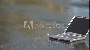 Laptop computer falling onto pavement and smashing to pieces in slow motion; 1000fps