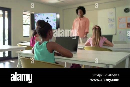African American child in class using laptop after peer raising hand, raising hand and replying. Teacher, students, classroom, computers, collaboration, engagement, colorful Stock Video Footage - Alamy