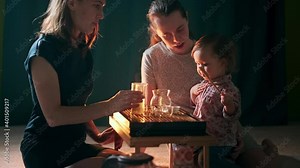 Tea ceremony with baby. Two women and baby drink tea at home. Lesbian homosexual couple sit with baby and perform tea ceremony at home