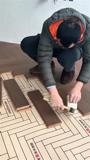 installing the brown wooden floor manually on the paper surface using a hammer