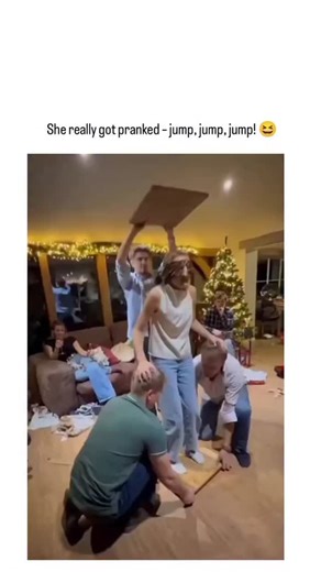 New memes on Instagram: "This instagram post shares a viral prank video from a Christmas-themed living room, where blindfolded friends lift a woman on a wooden board toward a fake ceiling made of cardboard, prompting her to jump upon "hitting" it—only for them to lower her mid-air, causing a flat fall that draws laughter amid scattered gifts. Garnering 23,000 likes and over 3 million views within two days, the clip exemplifies X's role in amplifying spontaneous holiday humor, with replies blendi