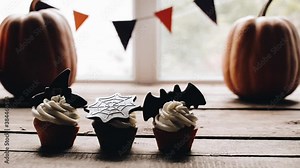 Someone takes a treat from the table. Sweets for halloween party on a wooden table. Halloween style party, candy bar and decorations with pumpkins. Halloween cake, cupcakes and muffins with chocolate