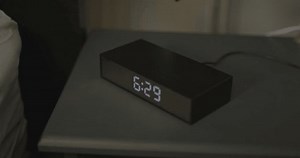 Alarm clock turns to 6:30 in the morning, a woman taps the clock and snoozes the alarm