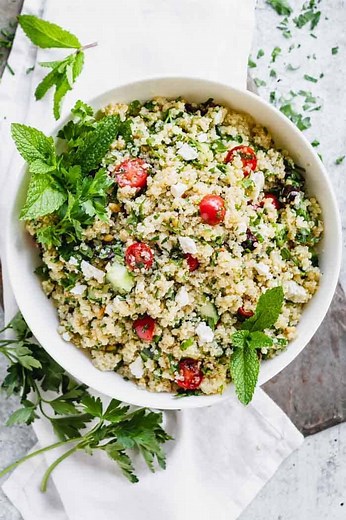 This Mediterranean Quinoa Salad is a healthy and tasty side dish for summer parties. It is popping with flavor and loaded with cucumbers, feta and olives with the addition of parsley and mint. It’s like a cross between Greek salad and quinoa tabbouleh all brought together with a garlic lemon dressing! | Healthy Seasonal Recipes