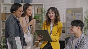 Creative designe Asian team brainstrom standing brainstrom discuss business startup team ideas,branding project with designer team at meeting table with desktop computer.discussion idea in office