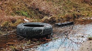 Used Worn Out Rubber Car Tyre Dumped Illegally in Shallow Water Creek