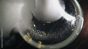 The hookah flask is on the table and it is enveloped in smoke. Top view of the hookah