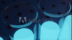 3D animation of an array of laboratory glass tubes or test tubes containing a blue-emitting colored liquid.