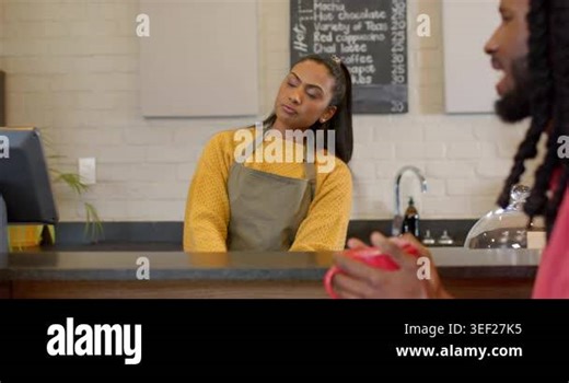woman customer raising red mug explaining order as Indian barista listening at coffee counter. Cafeteria, hospitality, rustic, cozy, interaction, communication, service Stock Video Footage - Alamy