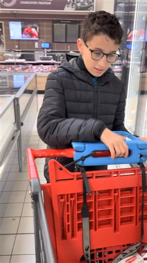 La CAA (communication alternative améliorée) pendant qu’on fait les courses bien sûr 🤩. Ici l’astuce, c’est 2 serres-cables amovibles (que j’emmène partout avec moi) pour fixer l’outil de CAA au caddie. Ça permet que l’outil soit stable et en bonne position pour faciliter le papotage en faisant ses achats 😉. | Maelange