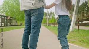 Father teach little daughter girl inline skating with roller in public park. Father's day. Happy family time together, Leisure sport activity.