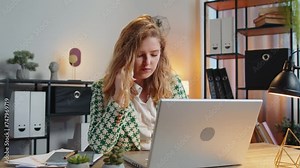 Young businesswoman freelancer answering to client on mobile phone call, using smartphone and laptop. Conversation. Caucasian woman girl working online remote distance job, talking at home office desk