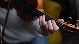 Close-up of a beautiful violin played by girl in slow motion. Beautiful young woman musician playing the violin