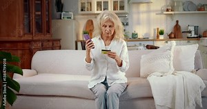 Elderly woman communicating with scammer by phone, lady feeling shock and crying . Data theft and security of finance, mature female retiree talking confidential data of credit card by phone, fraud