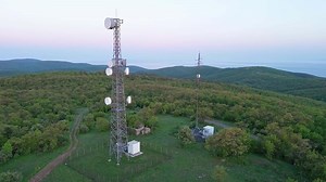 Cell towers overlooking lush hills and fields
