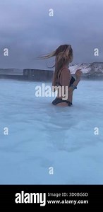 Blue Lagoon Iceland. The beautiful girl bathing in a geothermal pool. Woman enjoying blue lagoon. Young Girl Floating in Water in Iceland. Gorgeous blue water. Thermal Bath. Natural spa treatment.