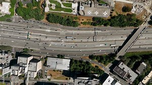 Lowering top down drone shot of traffic driving through Seattle's downtown freeways.