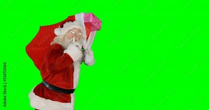 Santa claus carrying gifts in sack during christmas time on green background 4k