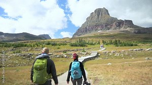 Hikers walking towards Clements Mountain on the Hidden Lake Trail in Glacier National Park, static