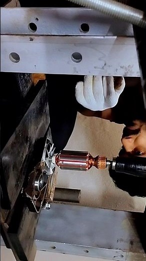 Bearings are being installed on the armature using a hydraulic press machine.