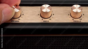 Hand adjusting volume control.Use hand to adjust the volume at the volume control button of the amplifier.