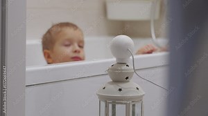 IP camera installed in bathroom to monitor the safety of small child taking a bath. Wireless security camera as baby video monitor. Parents watching child bathing in bathtub on smartphone screen. Stock Video