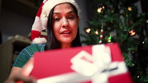 Download Woman opening a gift box at home for free