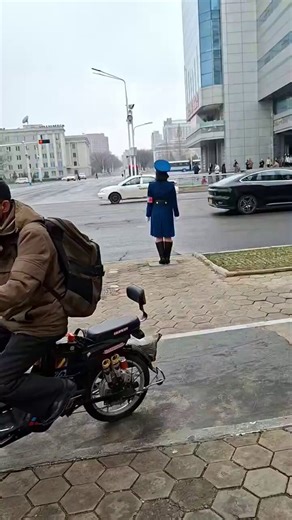 นักท่องเที่ยวชาวต่างชาติคนหนึ่งเดินทางไปเยือนเกาหลีเหนือและกำลังเดินเล่นอยู่บนถนนซองนีในใจกลางกรุงเปียงยาง สังเกตตำรวจจราจรหญิงคนหนึ่งยืนอยู่กลางถนน เคลื่อนไหวอย่างเป็นระบบเพื่อควบคุมการจราจรแม้จะมีสัญญาณไฟจราจรอยู่ทำงานเป็นกะ 1 ชม. พัก 1 ชม. ต่อเนื่องยาว 12 ชม.ตำแหน่งนี้ยังถูกมองว่า “มีเกียรติ” และมีเกณฑ์คัดเลือกเข้มงวดสำหรับผู้หญิงที่จะได้งานนี้ มีเงื่อนไขที่เข้มงวดหลายประการ รวมถึงเธอต้องเป็นโสดและต้องลาออกหากต้องการแต่งงานภาพที่ดูเป็นระเบียบ อาจมีอะไรมากกว่าที่เห็น… 🤔A foreign tourist visit