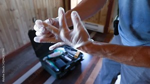 Indoor damp & air quality (IAQ) testing. Close-up and slow-mo footage of an indoor environmental quality (IEQ) inspector using personal protective equipment (PPE), application of disposable gloves.