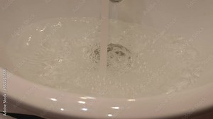 water is poured from the tap into the sink and does not drain due to a clogged drain. selective focus. flood in the apartment, faulty sewerage at home, home insurance, flooded neighbors