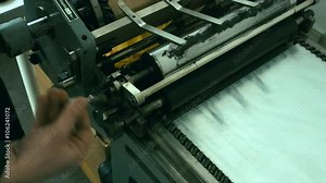 Caucasian male preparing a vintage letterpress machine for printing. Close up 4k 60 FPS. Shot with Blackmagic URSA Mini