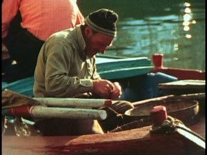 VENICE, ITALY, 1974, Chioggia fishing village, man repairing fishing net, sewing
