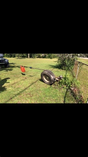 Stump pulling using a tire for leverage.