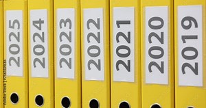 Row of bright folders for annual documentation on shelf