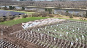 Footage of cartons on pallets containing solar modules and components for solar panels and installed racks for solar panels at the construction site of a photovoltaic park. Ground-mounted PV.