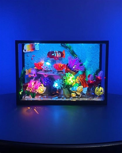 Dive into vibrant underwater light 🐟🪸🐠 This light kit bathes your LEGO® Tropical Aquarium in rich colours — from bright daytime blue to glowing nightlife effects with vivid coral, seaweed sways, and treasure chest bursts of warm light. | Light My Bricks
